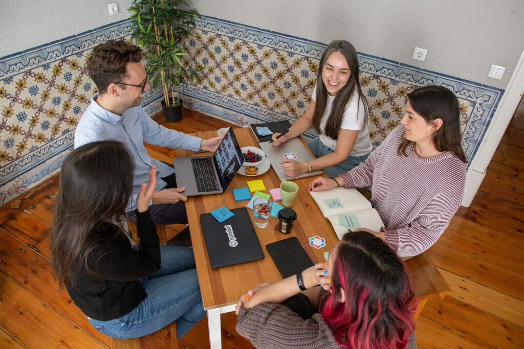 Nos formations a group of people sitting around a wooden table